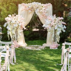 an outdoor wedding setup with white chairs and pink flowers