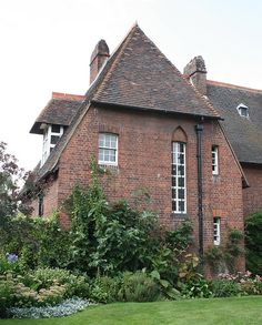 an old brick house is surrounded by greenery