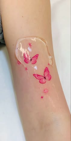 a woman's arm with pink butterflies on it