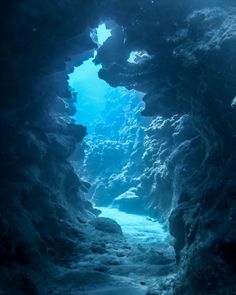 an underwater cave with blue water and rocks on the bottom, looking into the distance