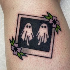 a couple of ghost hands in a frame with flowers on the side of a woman's thigh