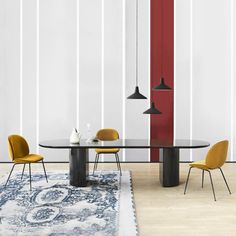 a dining table with yellow chairs in front of a white wall and red vertical blinds