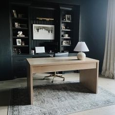 a home office with black walls and white carpet