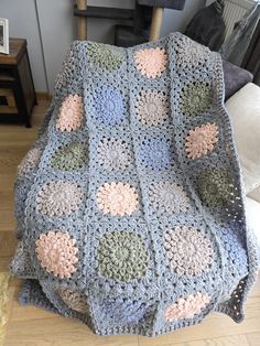 a crocheted blanket sitting on top of a wooden chair