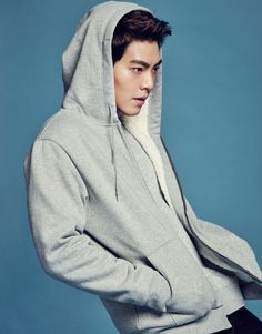 a young man in a grey hoodie is posing for a magazine cover shot with his hands on his hips