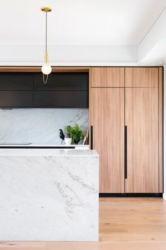 a kitchen with marble counter tops and wooden cabinets