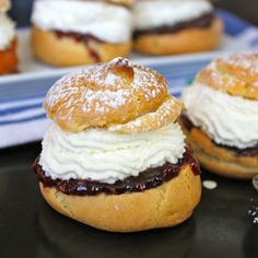 two pastries with cream and jelly on them are sitting on a plate next to other pastries