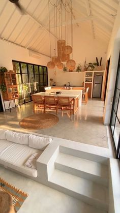 a living room filled with furniture next to a kitchen