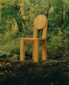 a wooden chair sitting on top of a stone wall