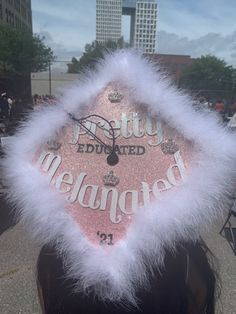 a pink and white furry hat with the words pretty eduted on it's side