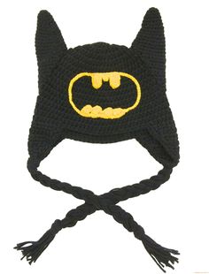 a crocheted batman hat with a bat symbol on the front and yellow eyes