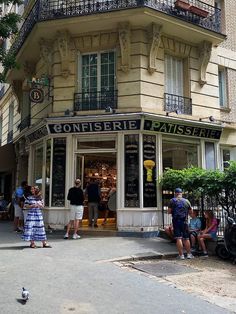 people are standing in front of a building with balconies on the second floor