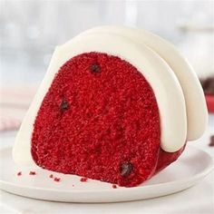 a red velvet cake with white frosting and chocolate chips on the top, sitting on a plate