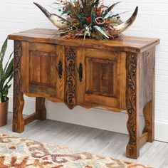 a wooden cabinet with two doors and some plants on top