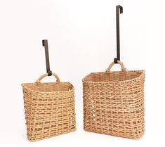 two wicker baskets sitting side by side with one holding an umbrella in the other