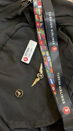 there is a pair of scissors on the back of a black bag with a lanyard