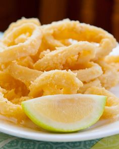 some fried food on a white plate with a lime