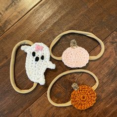 three crocheted pumpkins on a wooden floor