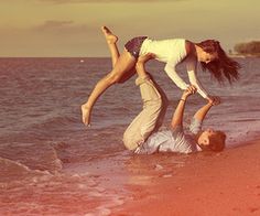 two people are playing on the beach with each other