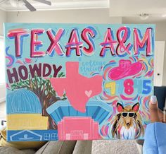 a person holding up a sign that says texas a & m, hodgy