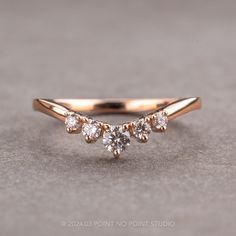 a gold ring with three diamonds on it, sitting on a gray surface in front of the camera