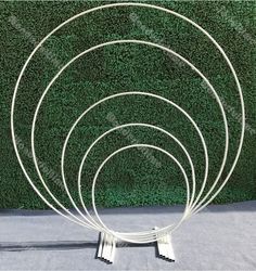 four circular metal sculptures sitting in front of a green wall