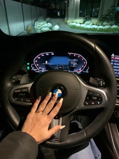 a person driving a car with their hand on the steering wheel and dashboard screen showing