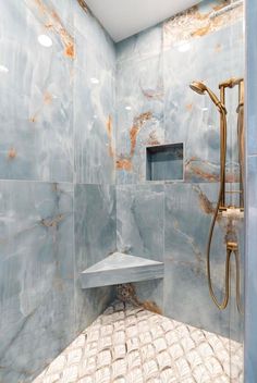 a bathroom with marbled walls and flooring, including a walk - in shower