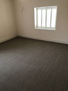 an empty room with a window and no curtains on the windowsill, is shown in this image