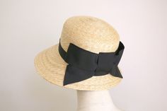 "A bonnet-style wide-brimmed hat made in genuine wheat straw braids which is true classic material. It has a wide front slanting brim, gradually narrowed to the back. It makes a great shadow and covers your face nicely from strong sunshine. The material is natural, fine-grade straw which is hard to find at a reasonable price these days.   Our hats are made with the highest quality standards by Japanese craftsmanship.    This listing is trimmed with a big bow in the back.  The ribbon is sewn on to the hat, not glued.   We have other listings of Cecil here.   https://www.etsy.com/au/shop/GrosgrainHat?ref=seller-platform-mcnav&search_query=Cecil Head Size  (please let me know when you order. ) Small  21 5/8\"  54cm  Medium 22\" 57cm  Large 22 3/4\"  59cm XL 60-63cm ( we make a custom-size ord Classic Brimmed Woven Straw Hat, Elegant Woven Brimmed Straw Hat, Classic Cloche Hat For The Beach, Classic Woven Straw Hat For Kentucky Derby, Elegant Natural Straw Hat Bands, Elegant Brimmed Straw Hat, Classic Adjustable Panama Hat For Garden Party, Elegant Natural Brimmed Cloche Hat, Classic Summer Cloche Hat