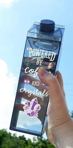 someone holding up a water bottle with the words powered by coffee and crystals on it