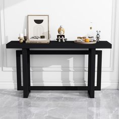 a black table with pictures and candles on it in front of a white wall,