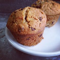 two chocolate chip muffins on a white plate