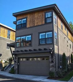 a two story house with three car garages in the front and side of it