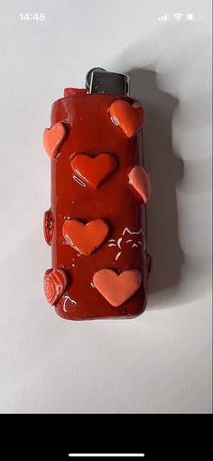 a bottle with hearts on it sitting on top of a table next to a white wall