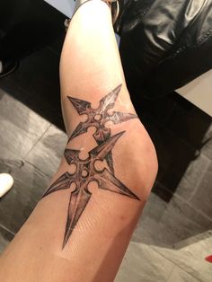 a person with a tattoo on their arm has a cross and two swords tattooed on it