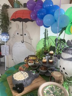 a table topped with lots of food and balloons