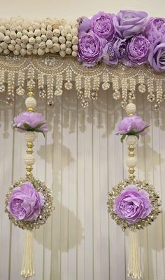 purple flowers are hanging from the ceiling in front of beaded curtains and chandeliers