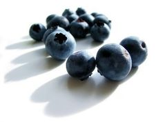 blueberries are arranged on a white surface