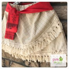 a red and white dress hanging on a brick wall