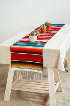 a table that has a potted plant on it and a blanket over the top