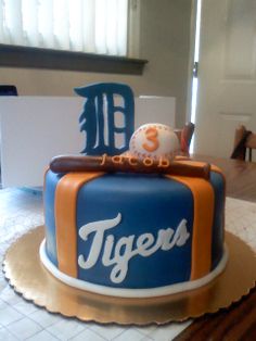 a detroit tigers cake with the number 8 on it and an orange and blue frosting