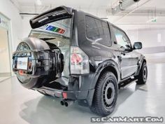 the back end of a black truck in a garage