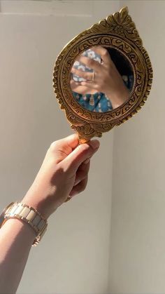 a person holding up a mirror with their hand on it and the reflection of someone's hand in the mirror