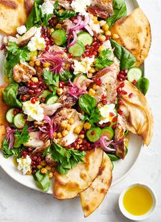 a white plate topped with salad and pita bread