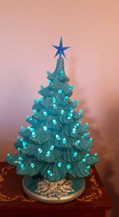 a small blue christmas tree with lights on it