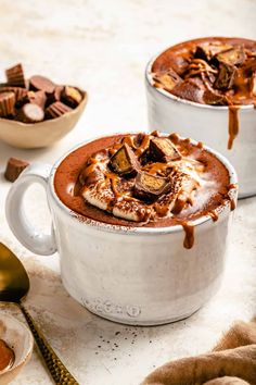 two white mugs filled with hot chocolate and marshmallows