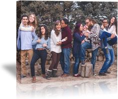 a group of people standing next to each other in front of some trees and rocks