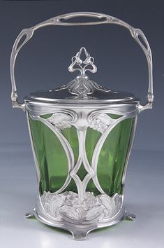 an antique silver and green glass ice bucket