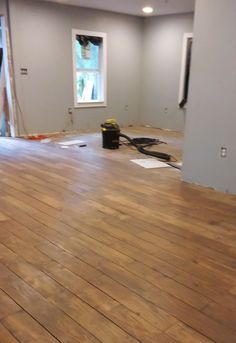 an empty room with hard wood flooring being installed